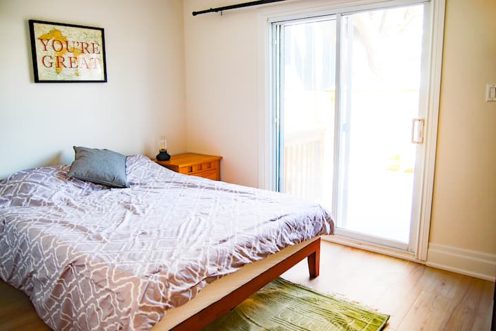 غرفة نوم رئيسية بسرير كوين ومدخل إلى الفناء