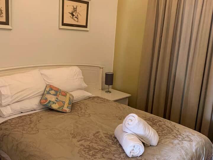 Chumba cha kulala chenye starehe kilicho na matandiko bora, meza za kando ya kitanda na mwanga mzuri kwa ajili ya kupumzika usiku