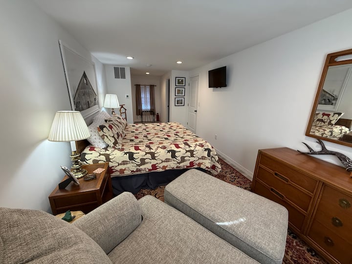 The Deer Room!  Second floor King Suite with attached full bathroom.  Seating area to enjoy the SmartTV and relax in private.  A closet, extra linens, fan, and luggage rack are also offered.  