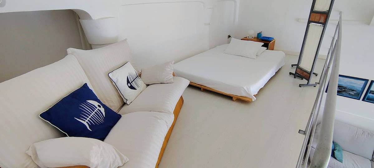 במעבר יש ספה נוחה ומיטת קווין סייז (פוטון). העיצוב הבסיסי מקוזז על ידי הנוף של הים הכחול למטה.