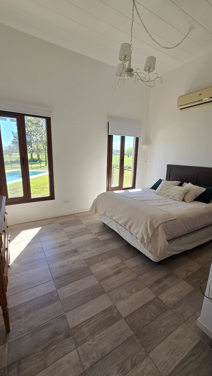 Veliki prozori s pogledom na bazen, vrt s drvećem i lagunu u daljini. Jedinstveni izlazak i zalazak sunca čine ovu spavaću sobu posebnim mjestom.