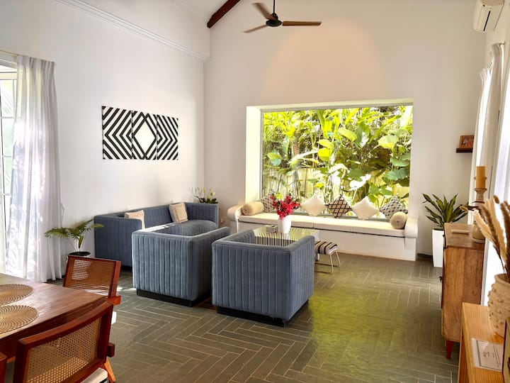 This gorgeous Santorini-style living room features a spacious, sun-filled layout, elegant white inte