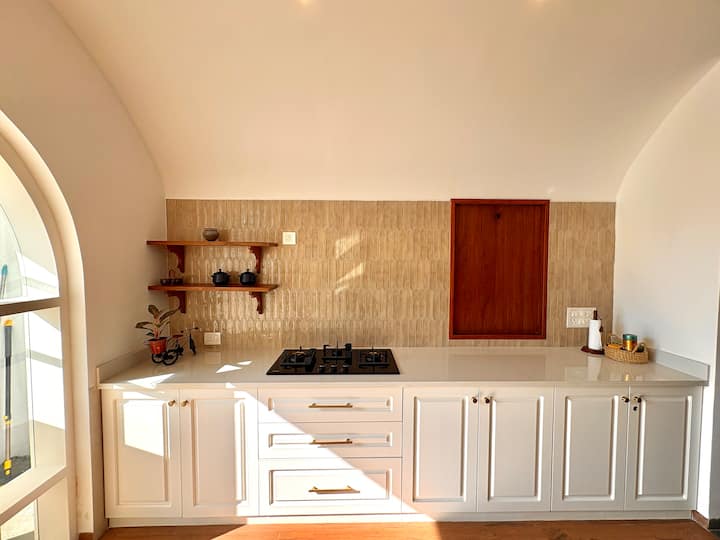 An airy white European-inspired kitchen offering a spacious layout, contemporary appliances, and abu