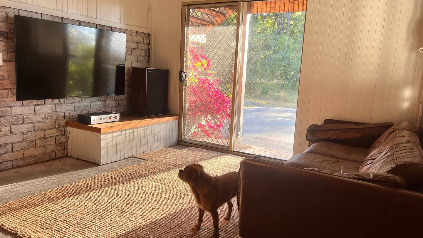 Downstairs lounge with TV and doors to the garden