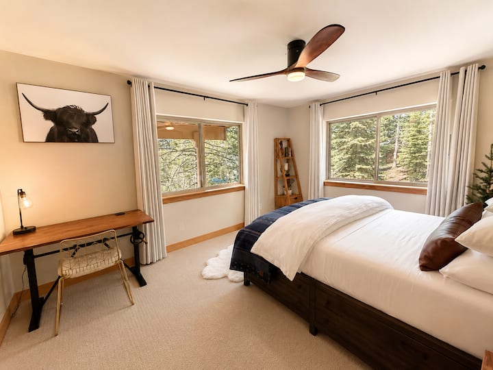 Aspen Room — ფართო საძინებელი „queen‑size“ ზომის საწოლით, პრემიუმ‑კლასის სასტუმროსთვის დამახასიათებელი თეთრეული, რეგულირებადი სამუშაო მაგიდა და ტყის ფართო ხედები.
