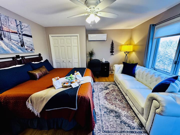 Another view of bedroom 3: the upper level with a king bed, a mini-split, a workspace, and a shared bathroom.