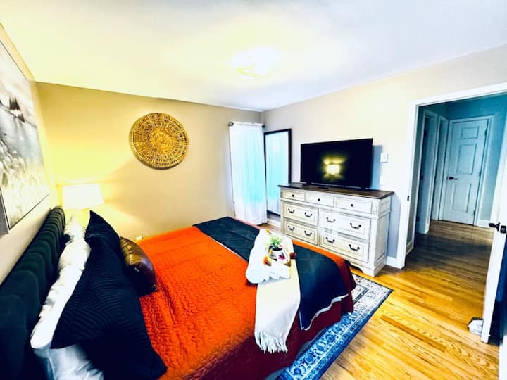 Another view of bedroom 4: the upper level with a king bed, a TV, and a shared bathroom.