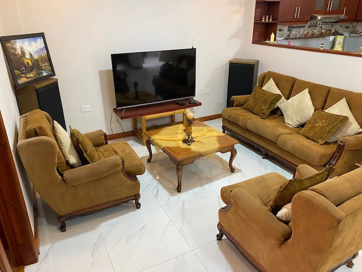 غرفة معيشة واسعة مع تلفزيون 55 بوصة، تحتوي على قفزات تلفزيون