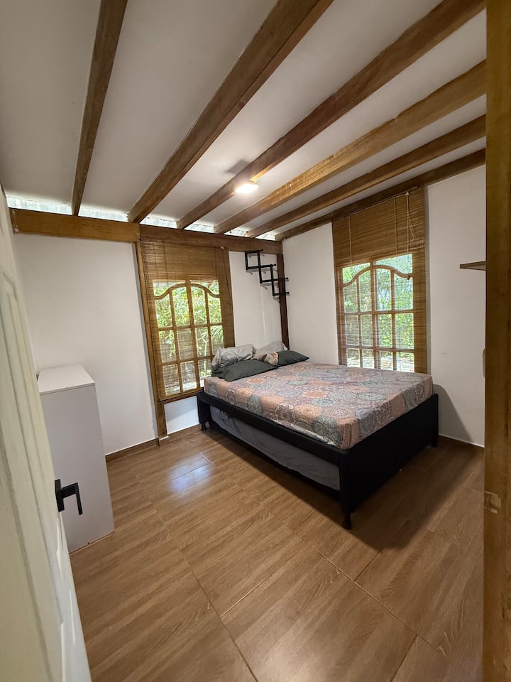 ️ Dhomë me bukuri natyrore dhe tinguj lumi
E ngrohtë dhe e ndritshme, me një krevat dopio, tavan druri dhe dritare të mëdha që ofrojnë një pamje të bukur të mjedisit të gjelbër. Ideale për të pushuar dhe për të shijuar qetësinë e ambientit. 