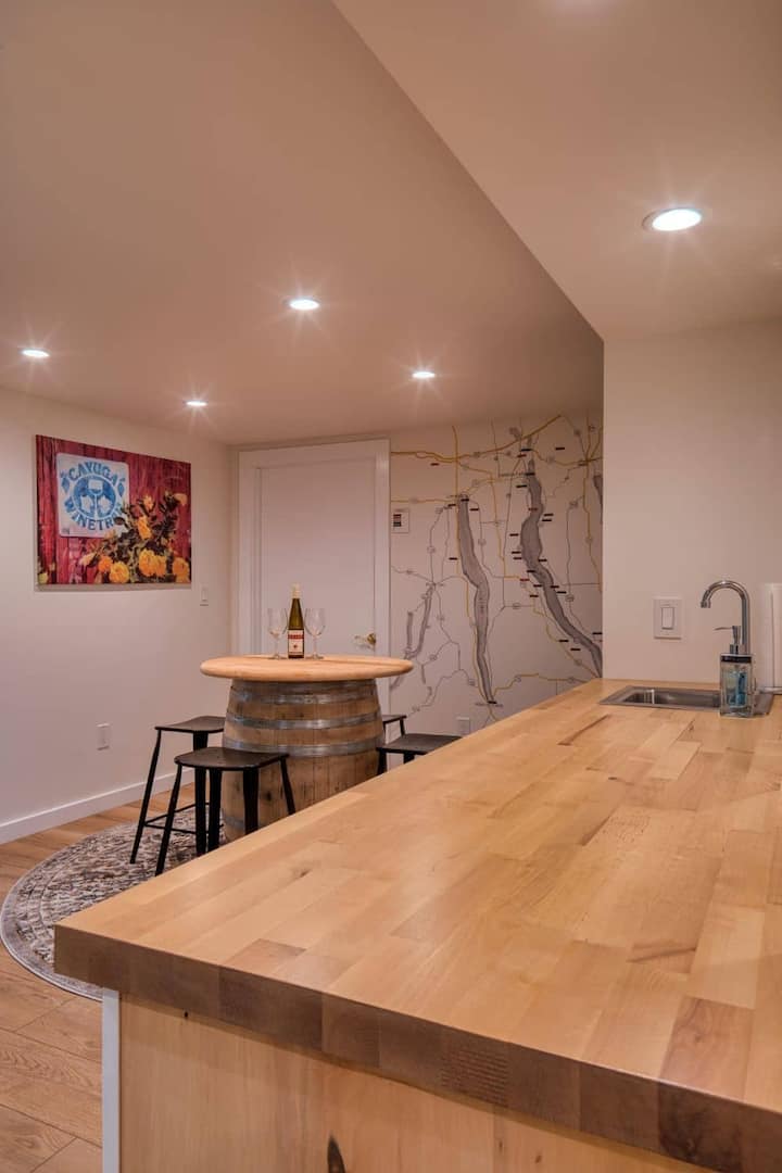 The barrel room features a hand-painted map of our favorite wineries, waterfalls, nature spots, and more. Adjacent to this space is the 5th dedicated sleeping area with a queen bed, workspace, backyard access, and a privacy curtain instead of a door.