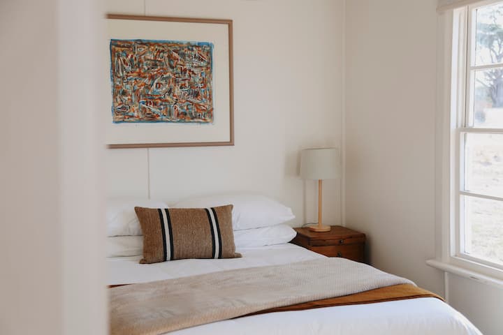 A comfortable queen bed and Tasmanian artwork in the master bedroom