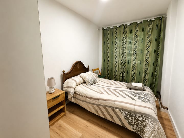 Dormitorio del apartamento con cortina verde