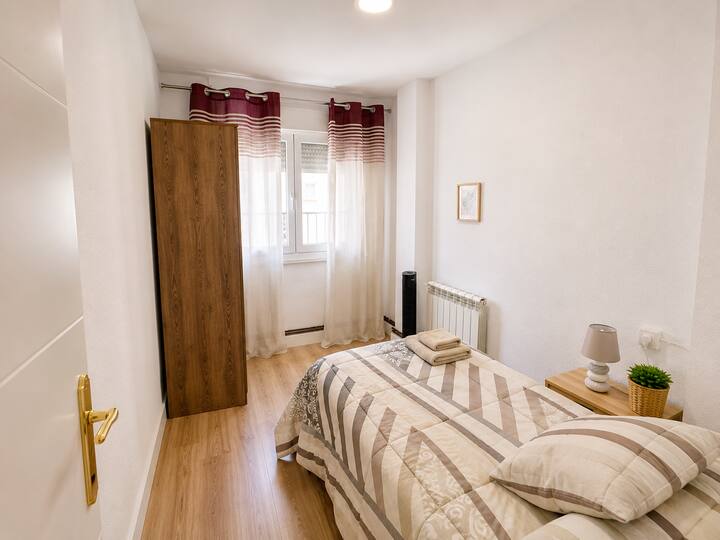 Dormitorio con armario de madera y cortina roja
