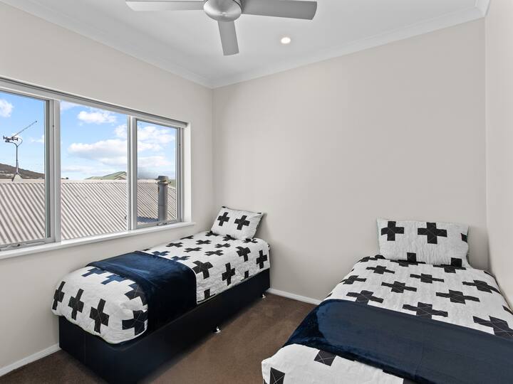 Två enkelsängar med skjutdörrgarderob och takfläkt.