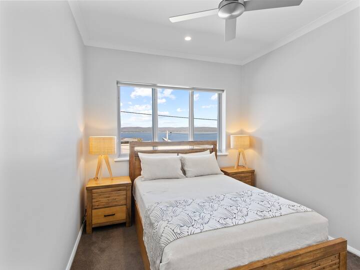 Queen size säng, med skjutdörr garderob och takfläkt.