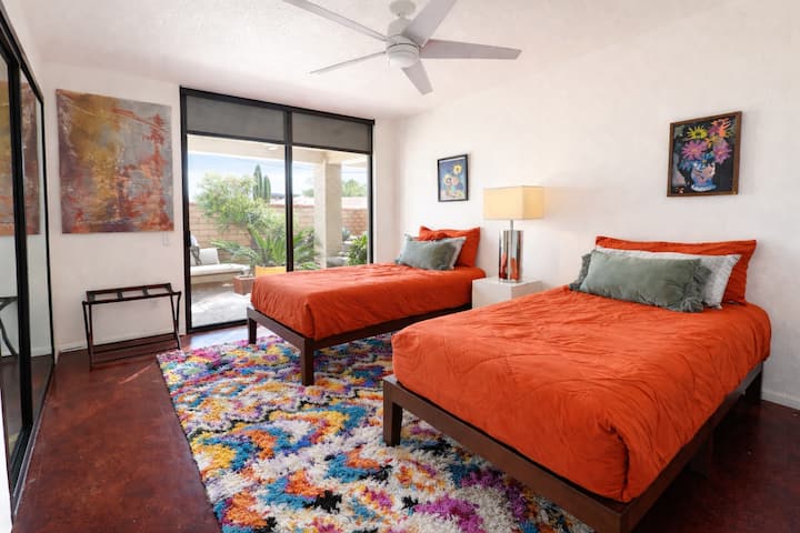 two twin beds with a private patio that leads out to the courtyard where there are fruit trees, this access also connects to the pool area