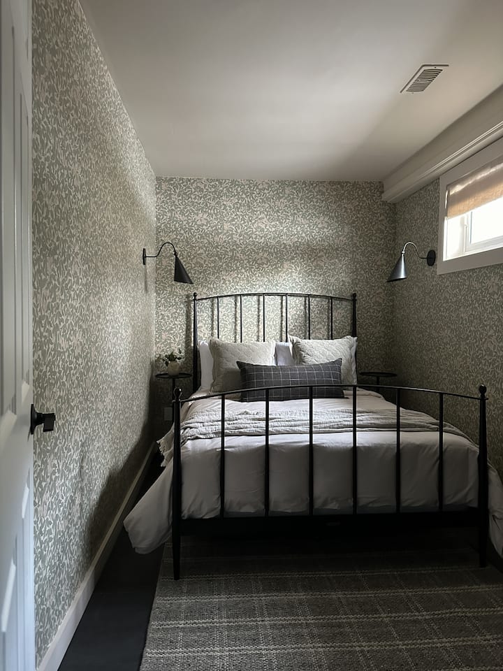 The 3rd bedroom is a cozy space with double bed, Roman shades, and freestanding closet. 