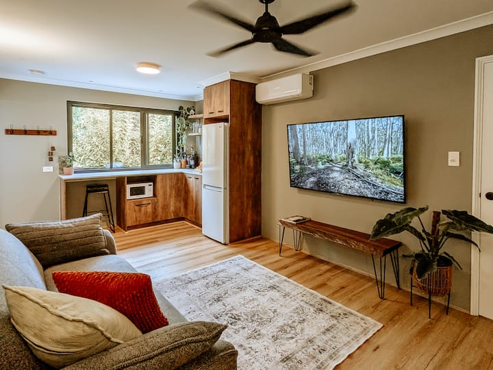 Relax in the comfort of the open-plan living space with a QS sofa bed, aircon & ceiling fan. A kitchen, 65" Smart TV & peaceful views through the stacker window make it perfect for a cosy evening or laid-back winter escape.