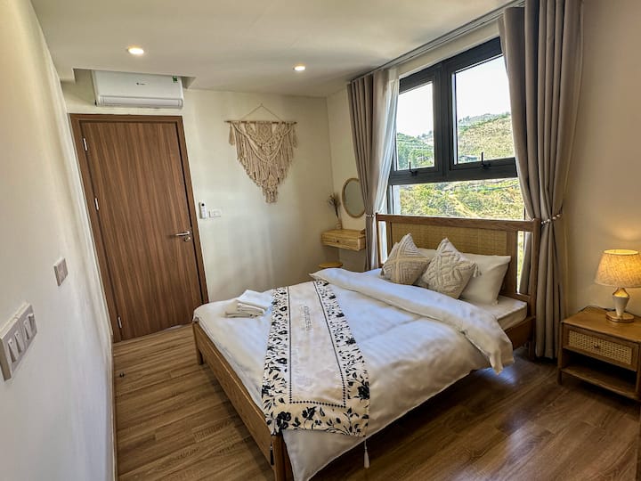 Phòng ngủ chính ấm cúng tại 1991 Home có giường queen thoải mái, khăn trải giường mềm mại, đồ nội thất gỗ ấm áp và ánh sáng tự nhiên. Một nơi nghỉ ngơi yên tĩnh, tối giản cho những đêm nghỉ ngơi sau khi khám phá Sapa.
