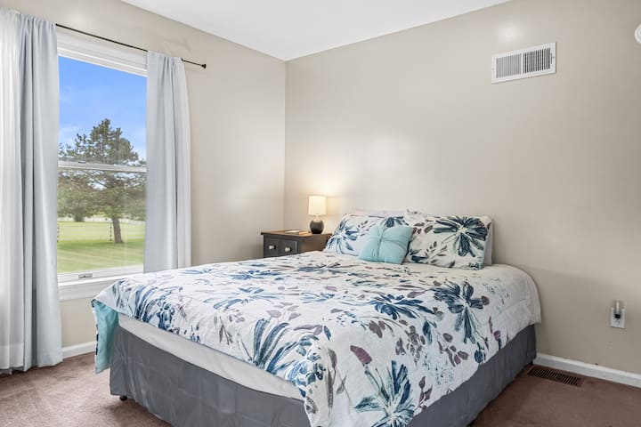 Teal room with a queen bed and closet.