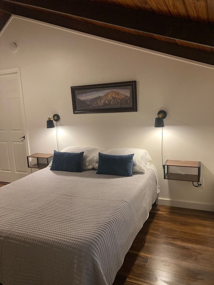 تحتوي هذه الهبوط الفسيحة على سرير بحجم كوين وإضاءة شمعدان ومنصات ليلية ومنافذ جانبية للسرير.