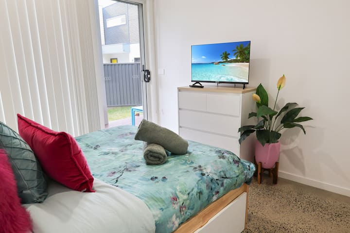 ห้องนอนชั้นล่างที่สองที่มีทางไปดาดฟ้าด้านหลังและสนาม