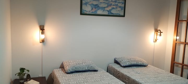 غرفة النوم الثانية - سريران مفردان وإمكانية الدخول إلى الحديقة الخلفية.