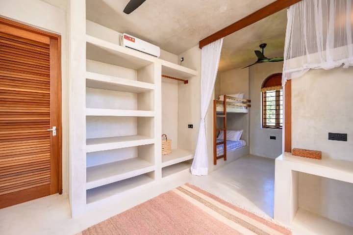 2 literas para cuatro personas.  Baño privado con bañera y ducha.  Ventilador y aire acondicionado. Espacio para una cama de bebé. Escritorio.