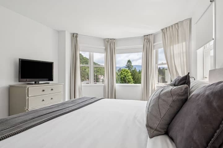 Este soleado dormitorio frontal en el último piso cuenta con una cama tamaño king, aire acondicionado de temporada, tocadores, un armario grande, ventilador y vista a la montaña