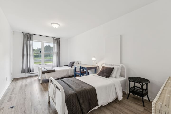 Esta recámara delantera en la planta baja cuenta con 2 cómodas camas individuales, una cómoda, un escritorio exclusivo para trabajar, un ventilador y vistas a los ciervos en el patio delantero. La habitación tiene una puerta que comunica con la recámara trasera y otra con el pasillo.
