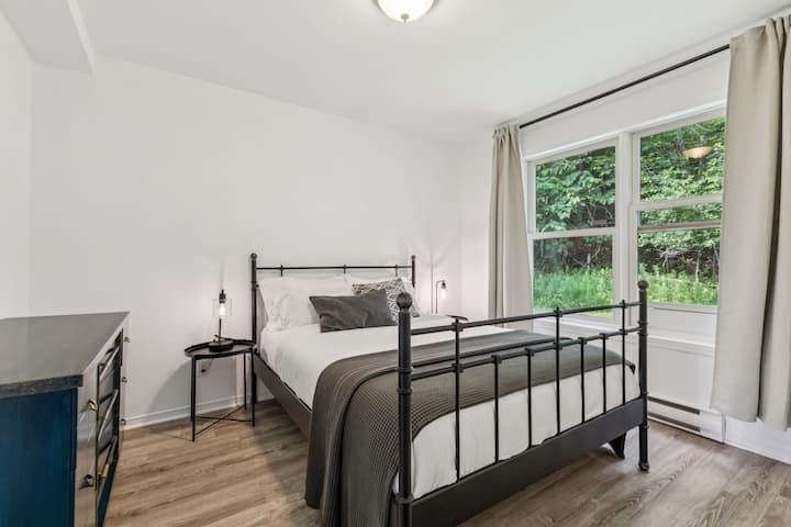Esta recámara trasera en la planta baja cuenta con una cómoda cama de matrimonio, tocador, clóset, ventilador, aire acondicionado de temporada y vista al bosque. La habitación tiene una puerta que comunica con la recámara principal y otra que da al pasillo.