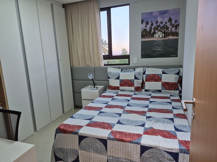 Sala social, que también funciona como suite reversible. Cuenta con una cama matrimonial estándar con cabecera, una cama nido, aire acondicionado, un armario, una silla de oficina, un escritorio, cortinas opacas y un ventilador. 