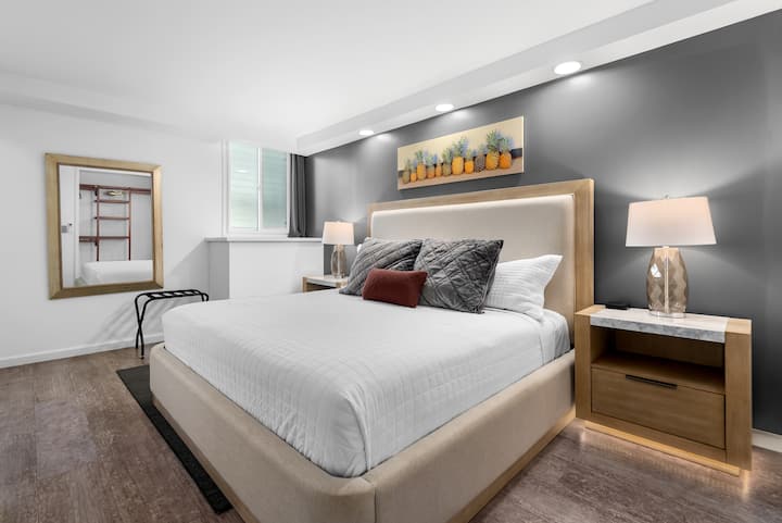 PRIMARY BEDROOM: This inviting space features a solid king bed topped with a high-end mattress and dressed in premium Comphy® linens, bedside tables with reading lamps and charging station. Designed as a peaceful place to rest and relax.