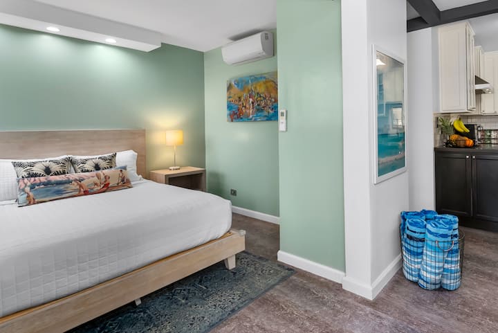 SECOND BEDROOM: Featuring a solid queen bed with high-end mattress and premium Comphy® linens, dedicated air conditioning, bedside tables and reading lamps, this cozy room is enhanced by local artwork and décor inspired by Waikīkī.