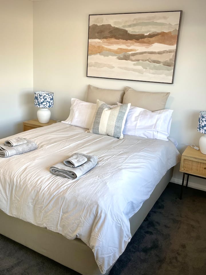 Bright, comfortable bedroom with plush bedding and soft natural light. 