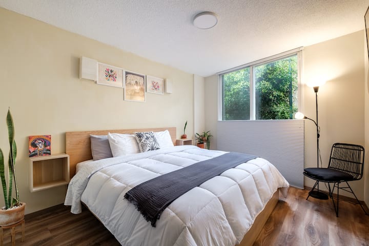 Საძინებელი დიდი ზომის საწოლით და ხეების ხედებით