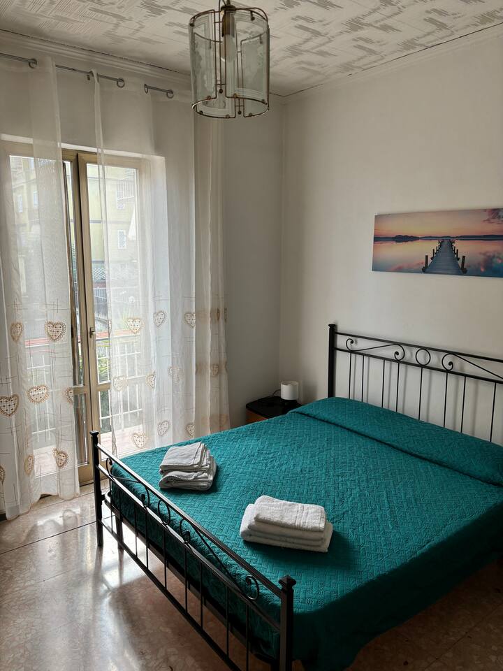 Bedroom with balcony and clothes rack.