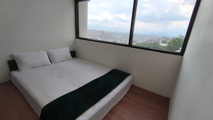 Dormitorio en el entrepiso con vistas a la ciudad de Bandung 