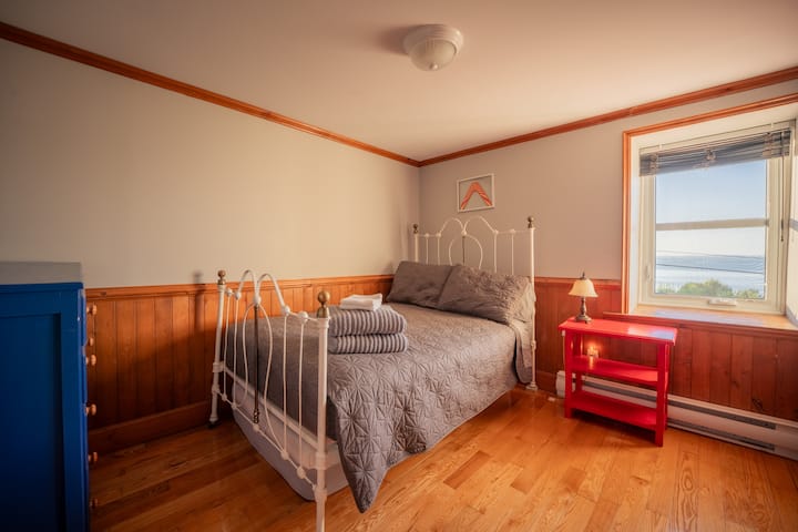 Room with a window overlooking the river. The size of the bed is between a single and a double bed.