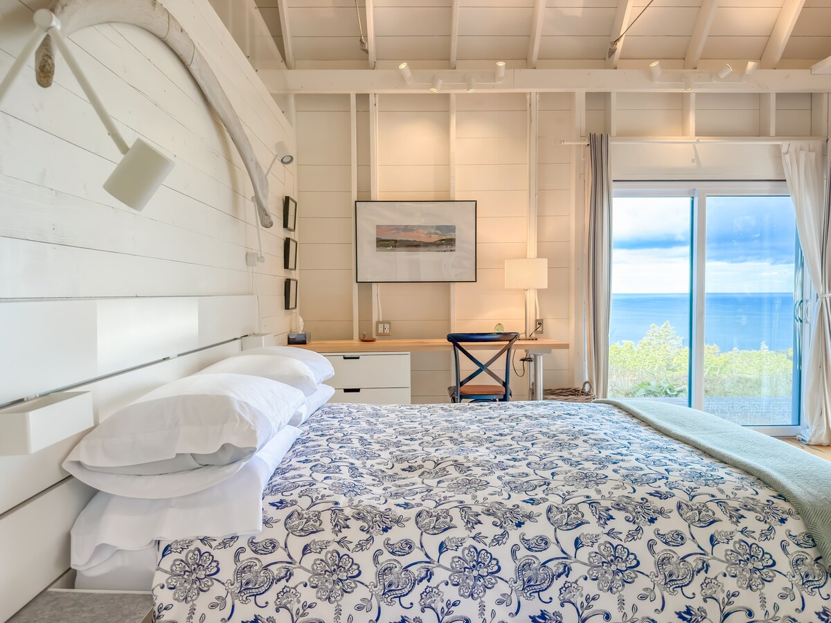 سرير كوين في كوخ غرفة النوم، مع ضلع حوت على الحائط. أرضيات صنوبر جميلة ومنطقة مكتب مع منافذ للشحن.
يتمتع كلا الكوخين بإمكانية الوصول إلى سرعة عالية سريعة جدًا من الألياف.