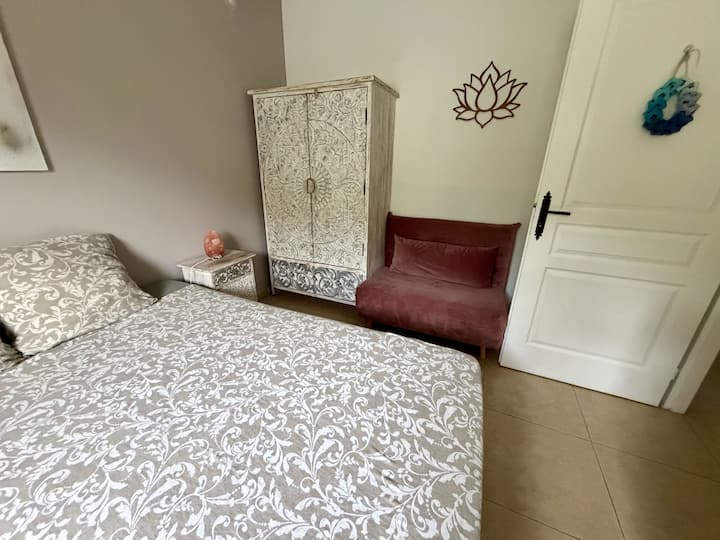 La habitación también cuenta con un gran armario, una mesa de cabecera y un cómodo sillón.