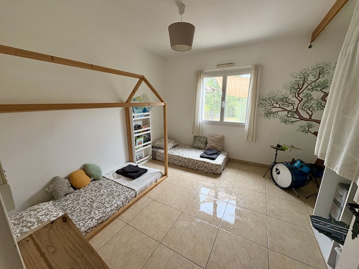 Habitación familiar con dos camas individuales, biblioteca y zona de juegos.