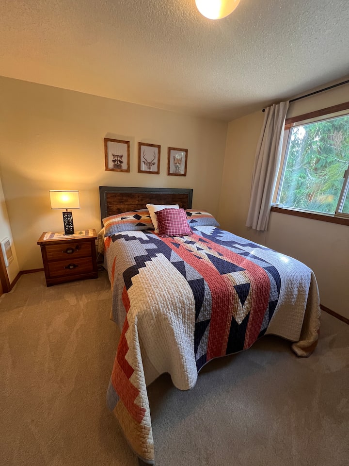 Relaxing upstairs queen bed with closet, nightstand, dresser and views of the backyard and Huckleberry Mt.
