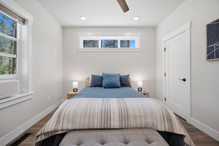 Secondary bedroom with TV, walk-in closet with dresser, hangers and hamper.