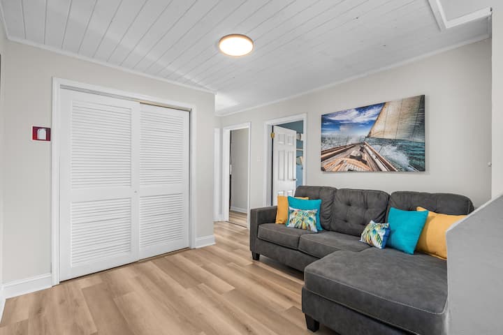 Additional sleeping space with a queen sleeper sofa in a shared area. The laundry room is tucked behind the louvered doors
