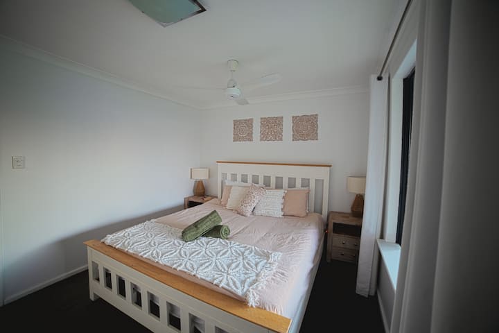 Large master bedroom with king sized bed, ceiling fan and double window blinds (block out and light diffusing). Cot is stored in the wardrobe