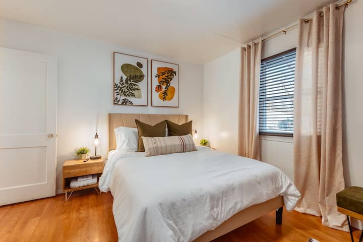 The primary bedroom features a queen bed with upholstered headboard.