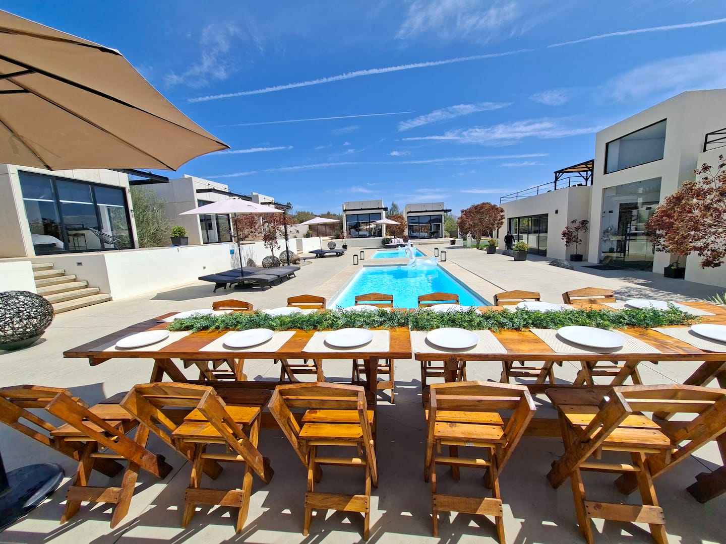 A long table with a garland runner, set beside the pool