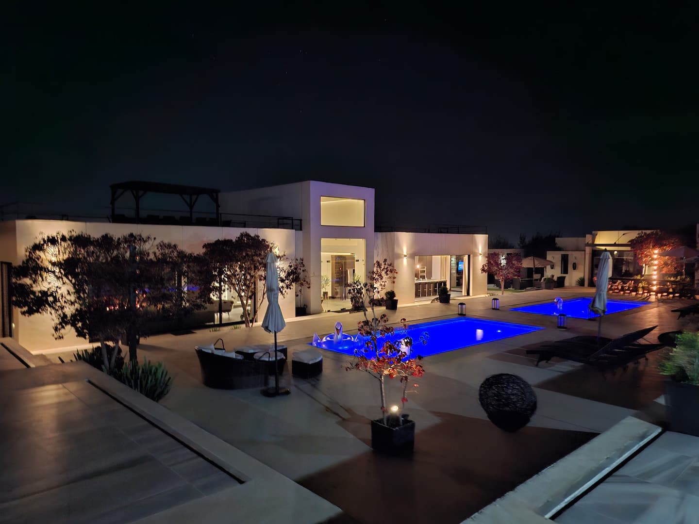 The courtyard at night, with the pools lit