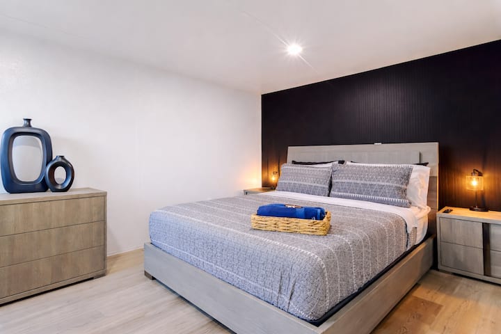 חדר שינה נוח עם מיטת קווין סייז, טלוויזיה חכמה, מצעים איכותיים, מיזוג אוויר ותריסי האפלה. כולל שידה, ארון עם מתלים, מגבות ללא תשלום ושולחן עבודה ייעודי – מושלם למנוחה או לעבודה מרחוק.